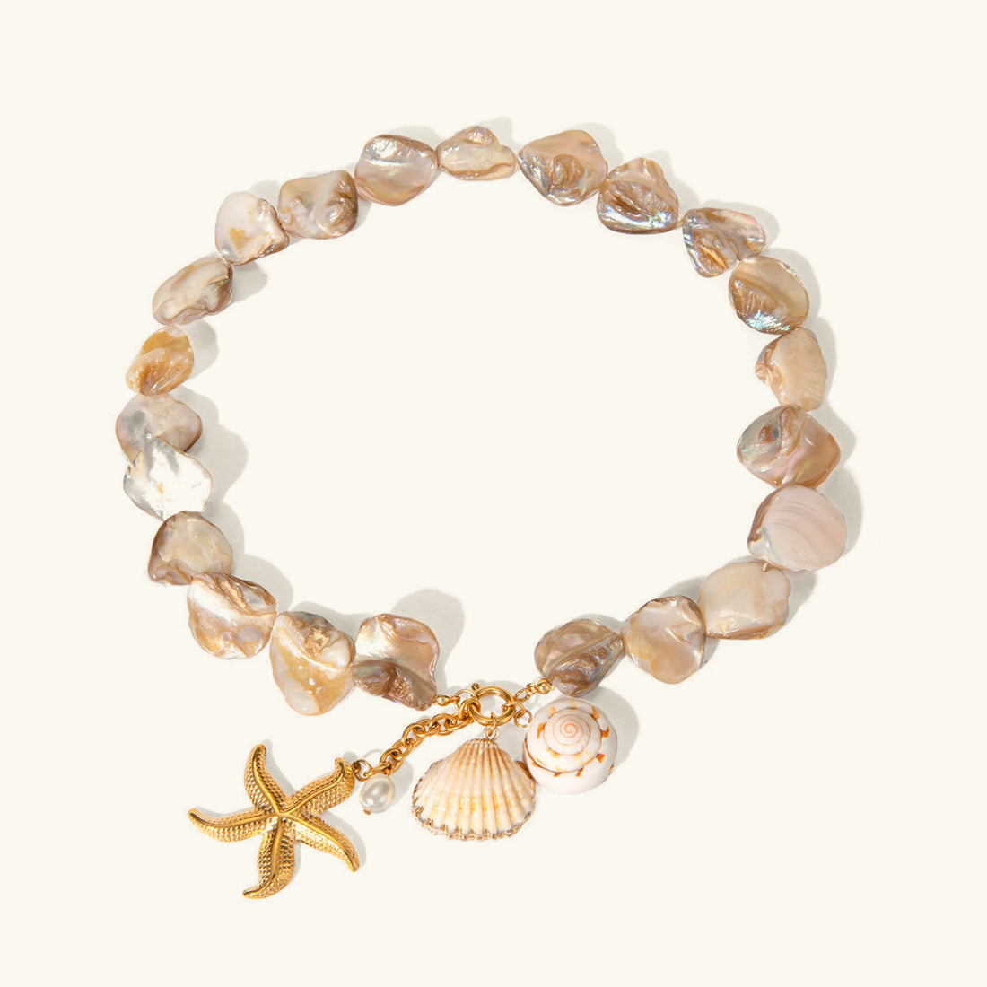 Bracelet with shell beads and gold charm on a white background