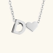 Silver necklace with 'D' and heart pendant on a white background