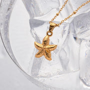 Gold starfish pendant necklace on a clear crystal background