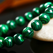 Green malachite beaded necklace on a dark surface