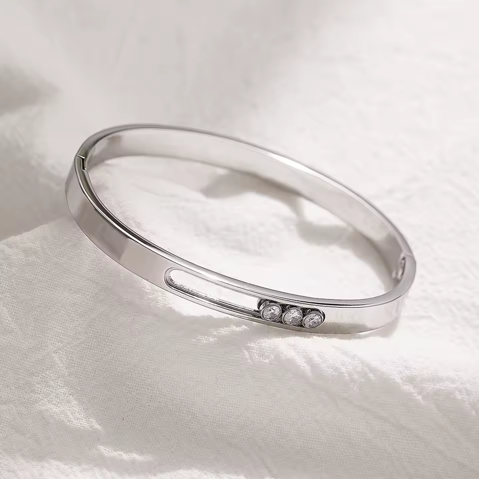 Silver bracelet with small stones on a white fabric background