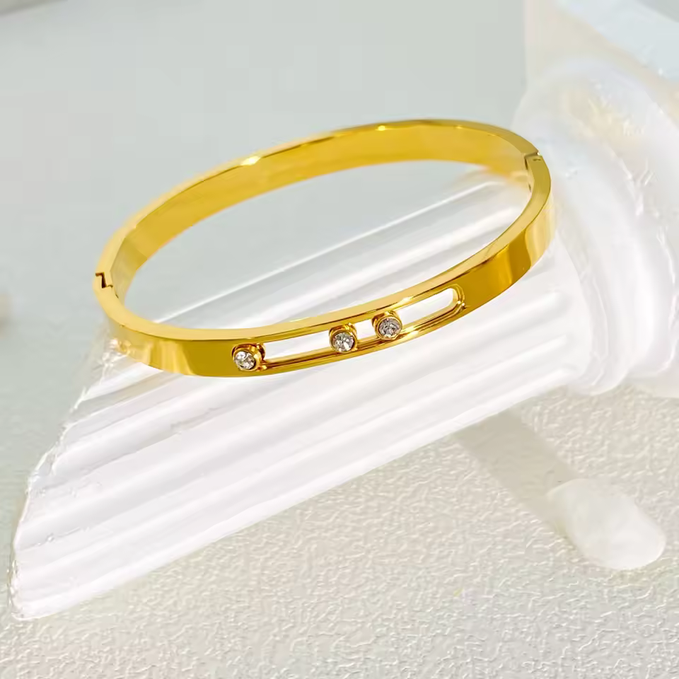 Gold bracelet with small crystals on a white background